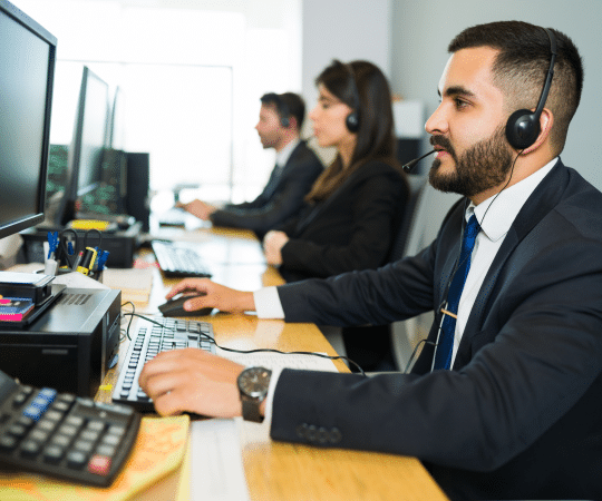 Attractive Latin Executive Providing Customer Service with Headset in a Busy Call Center
