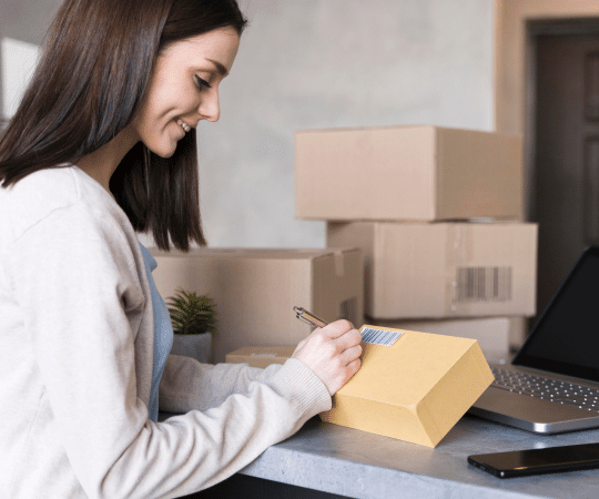 Side View of Woman Writing on Box at Work